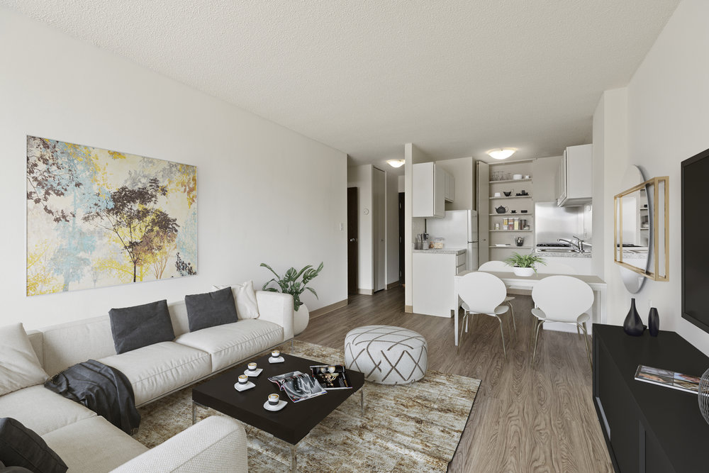 Modern open-plan living room and kitchen with neutral decor, white furniture, and a large abstract painting.
